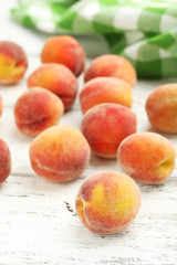 Ripe peaches fruit on a white wooden background