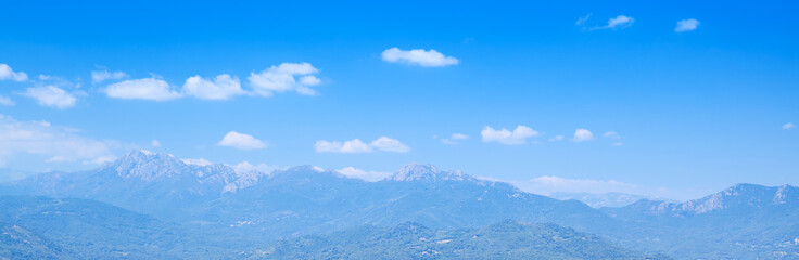 Mountains under bright cloudy sky. Corsica