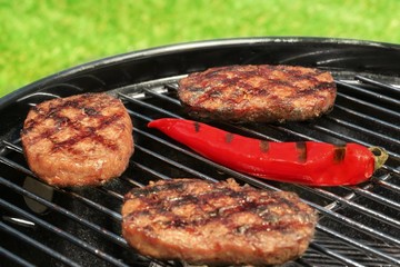 BBQ Hamburger Patties And Chili Pepper On The Hot Grill