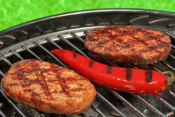 BBQ Hamburger Patties And Chili Pepper On The Hot Grill