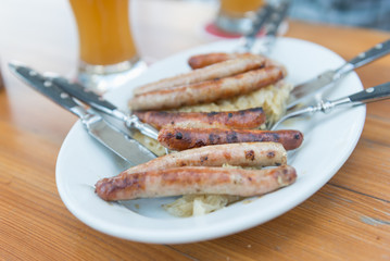Sausage with cabbage on white plate. Selective focus.