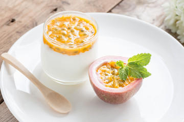 Yogurt with passion fruit on white plate.