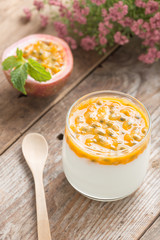 Fresh yogurt with passion fruit on wood table.
