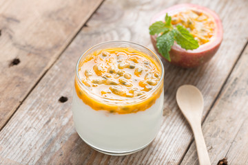 Fresh yogurt with passion fruit on wood table.