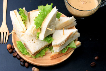 tuna sandwiches and hot coffee on black background