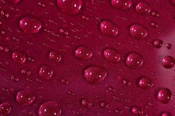 Water drops on the red surface. Selective focus.