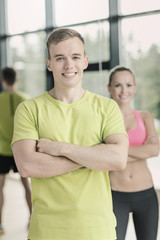 Fototapeta na wymiar smiling man and woman in gym