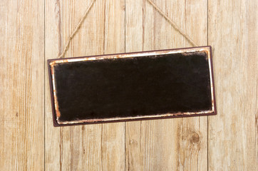 Leeres Blechschild vor einer Holzwand