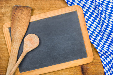 Obraz na płótnie Canvas Kochlöffel und Tafel mit einem bayerischen Tischtuch