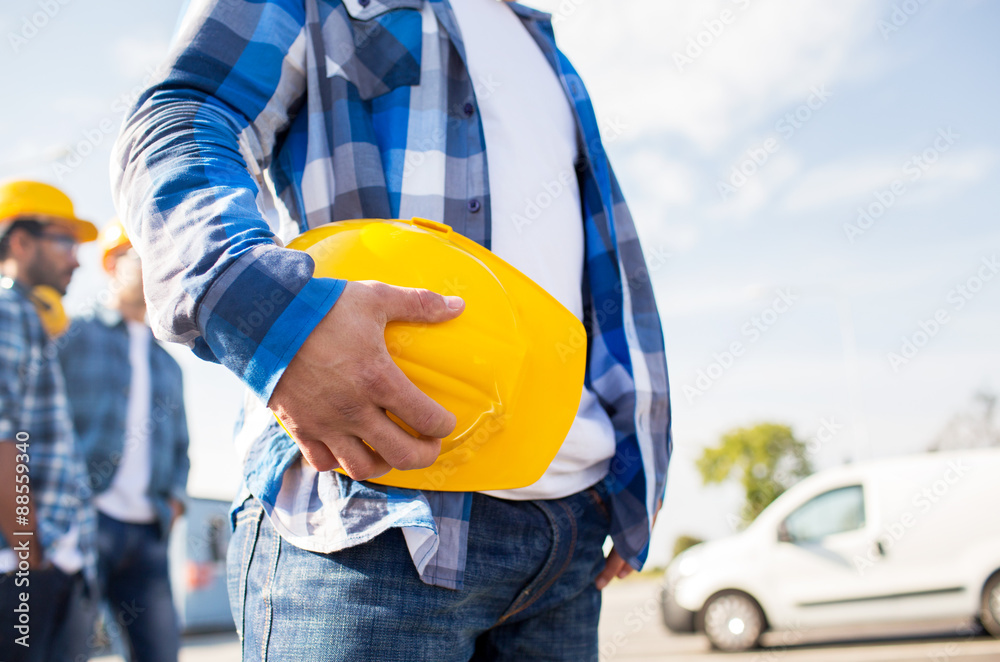 Wall mural close up of builder holding hardhat at building