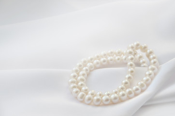 Elegant white background with lace, silk and pearl