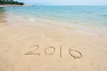 2016 written in sand, on tropical beach
