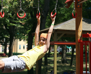 Fototapeta premium child plays with rings of outdoor playground