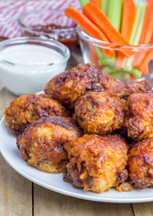 Roasted chicken served with celery and carrot sticks, blue cheese dressing and hot sauce