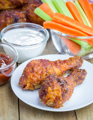 Roasted chicken served with celery and carrot sticks, blue cheese dressing and hot sauce