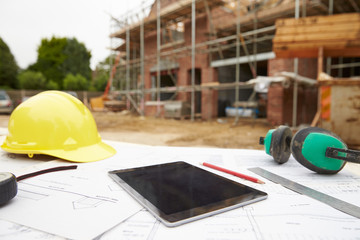 Close Up Of Plans And Digital Tablet On Building Site