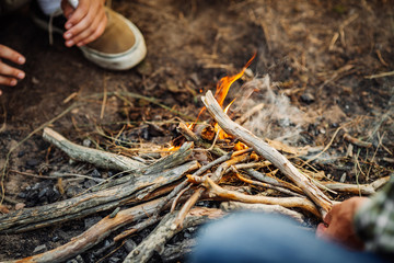 hand putting fir wood to fire