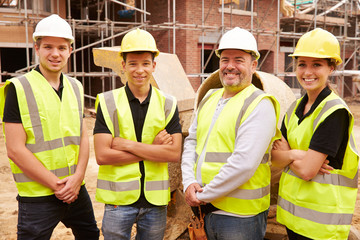 Portrait Of Builder On Building Site With Apprentices