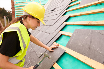 Female Construction Worker On Site Laying Slate Tiles - obrazy, fototapety, plakaty