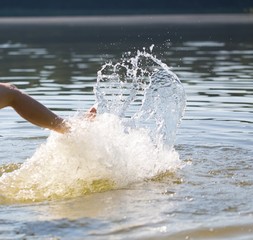 Girl splashing water in lake by her leg