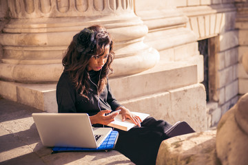 Cool urban girl using mobile technology at the city of London.