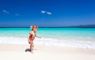 Fototapeta na wymiar Happy little girl on the beach
