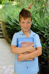 Cute boy is holding books - education concept, outdoor portrait