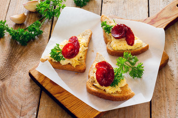 Bruschetta with cheese, garlic and jerked sausage on paper