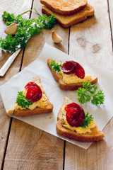Bruschetta with cheese, garlic and jerked sausage on paper, on w