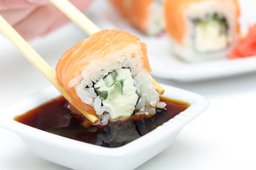 Sushi roll Philadelphia in chopsticks