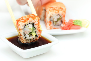 Sushi roll in chopsticks