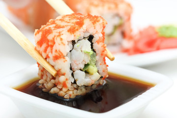Sushi roll in chopsticks