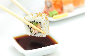 Sushi roll in chopsticks