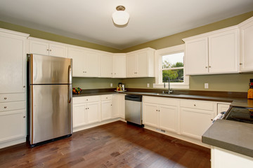 Classic kitchen with green interior paint, and white cabinets.
