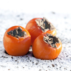 Delicious persimmons on white snow