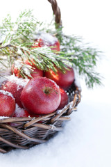 Red apples in basket in snow, outside
