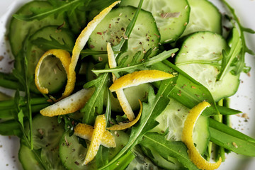 Green salad with cucumber, arugula and lemon peel, closeup
