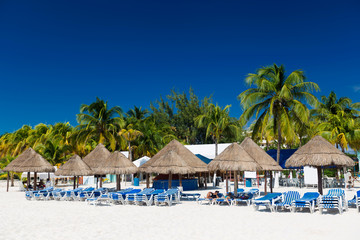 Caribbean beach with sun umbrellas and bed
