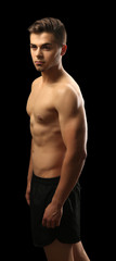 Fototapeta na wymiar Muscle young man on dark background