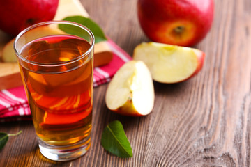 Glass of apple juice and fruits on table close up