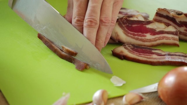 HD 1080 close up: chef chopping pancetta bacon onto small chunks using sharp knife