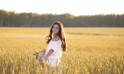 Naklejka na ściany i meble Smiling beautiful girl in a Golden wheat field turned