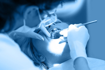 Dentist curing a female patient