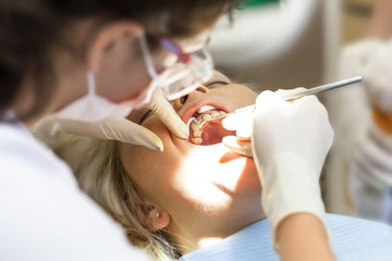 Obraz na płótnie Canvas Dentist curing a female patient