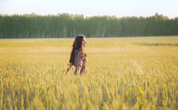 Slim girl in Golden wheat ears in the field