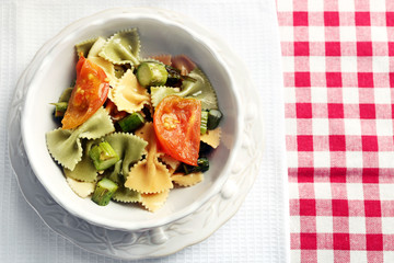 Roasted asparagus and tasty pasta with vegetables in bowl on wooden table background