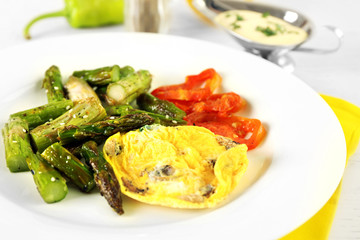 Roasted asparagus with fried egg on plate on table, close-up
