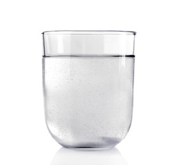 Pill in glass of water on light background