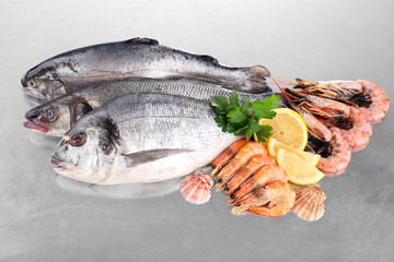 Fresh fishes and shrimps with spices  on metal background