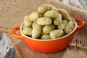 Ripe mulberries in bowl on table close up